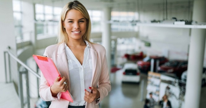 Picture of professional female salesperson working in car dealership